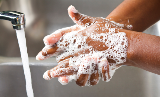 a person works up a lather while washing their hands